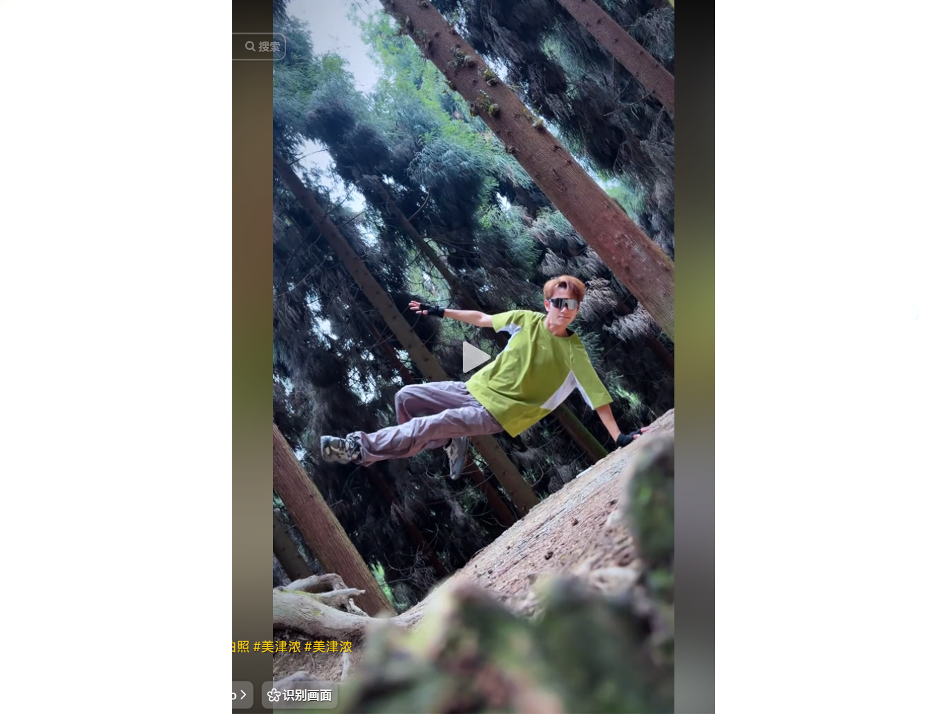 A person in a green shirt and sunglasses climbs a