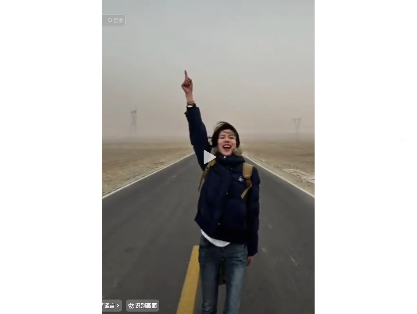 A person stands on a deserted road, pointing upwar