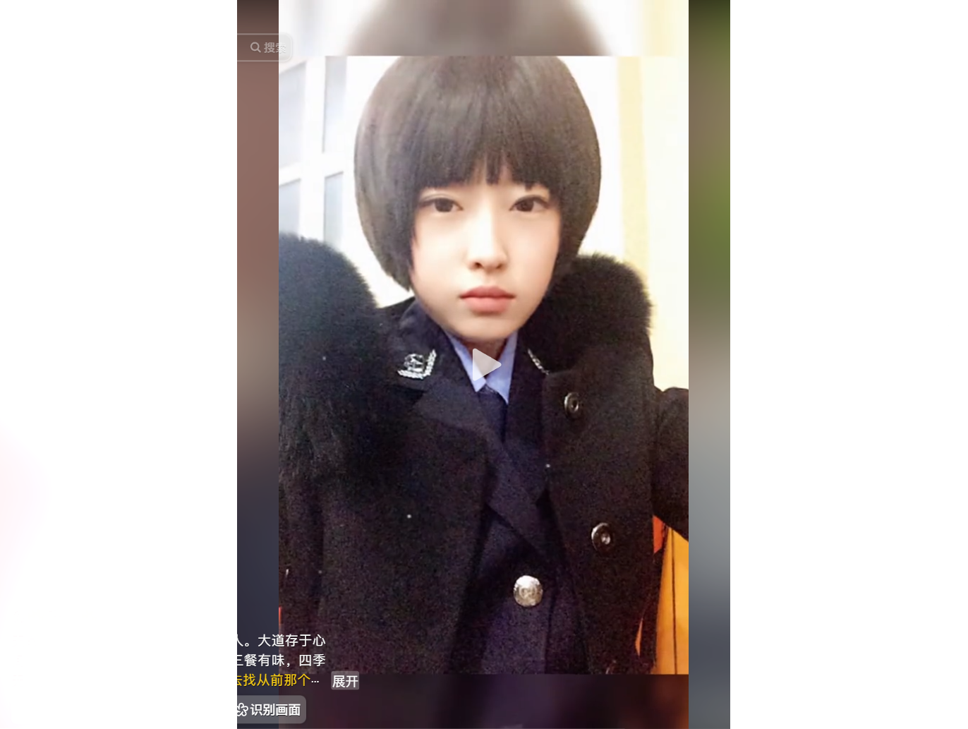 A person with a bob haircut wearing a dark coat wi