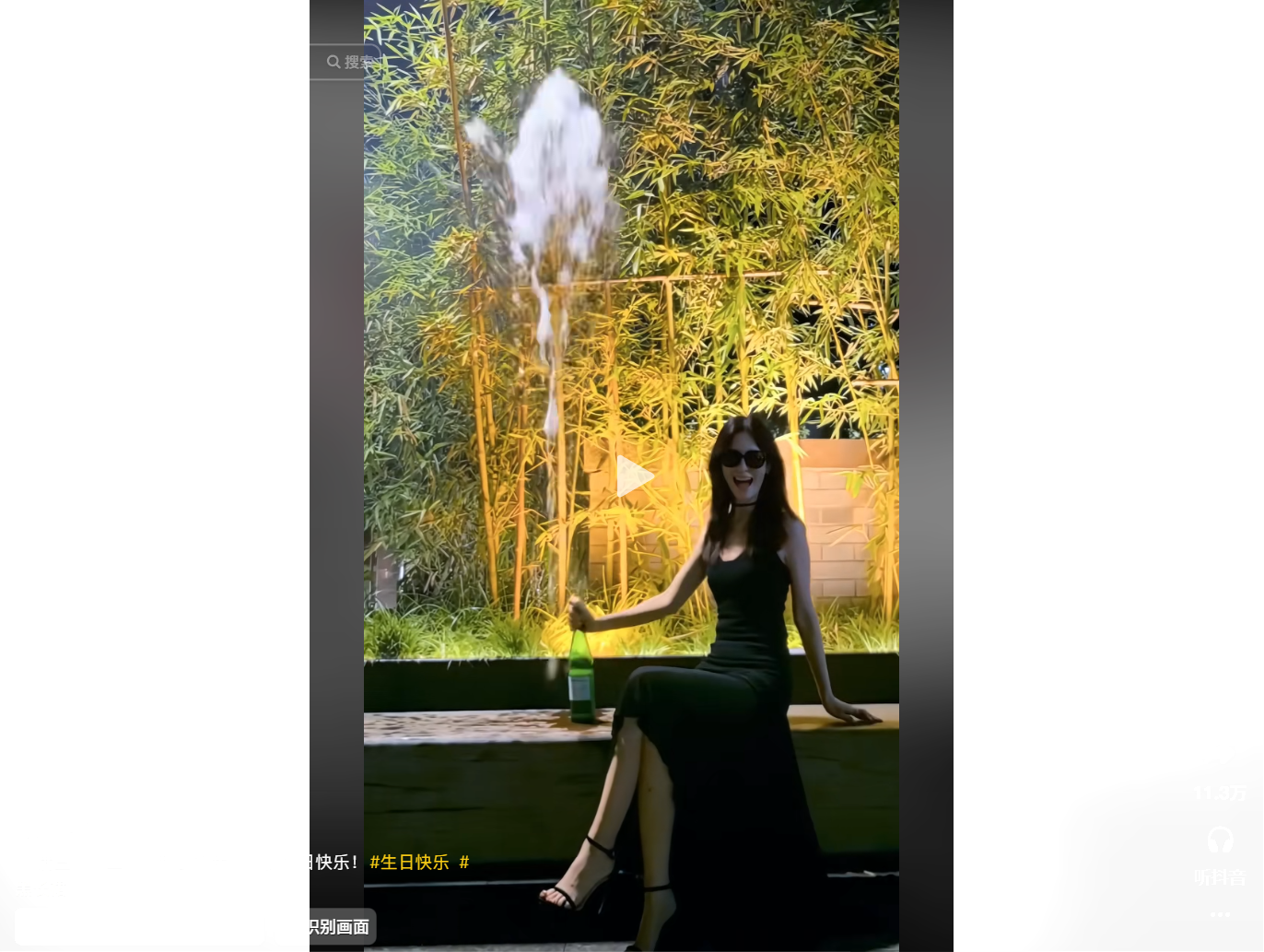 A woman in a black dress celebrates by opening a b
