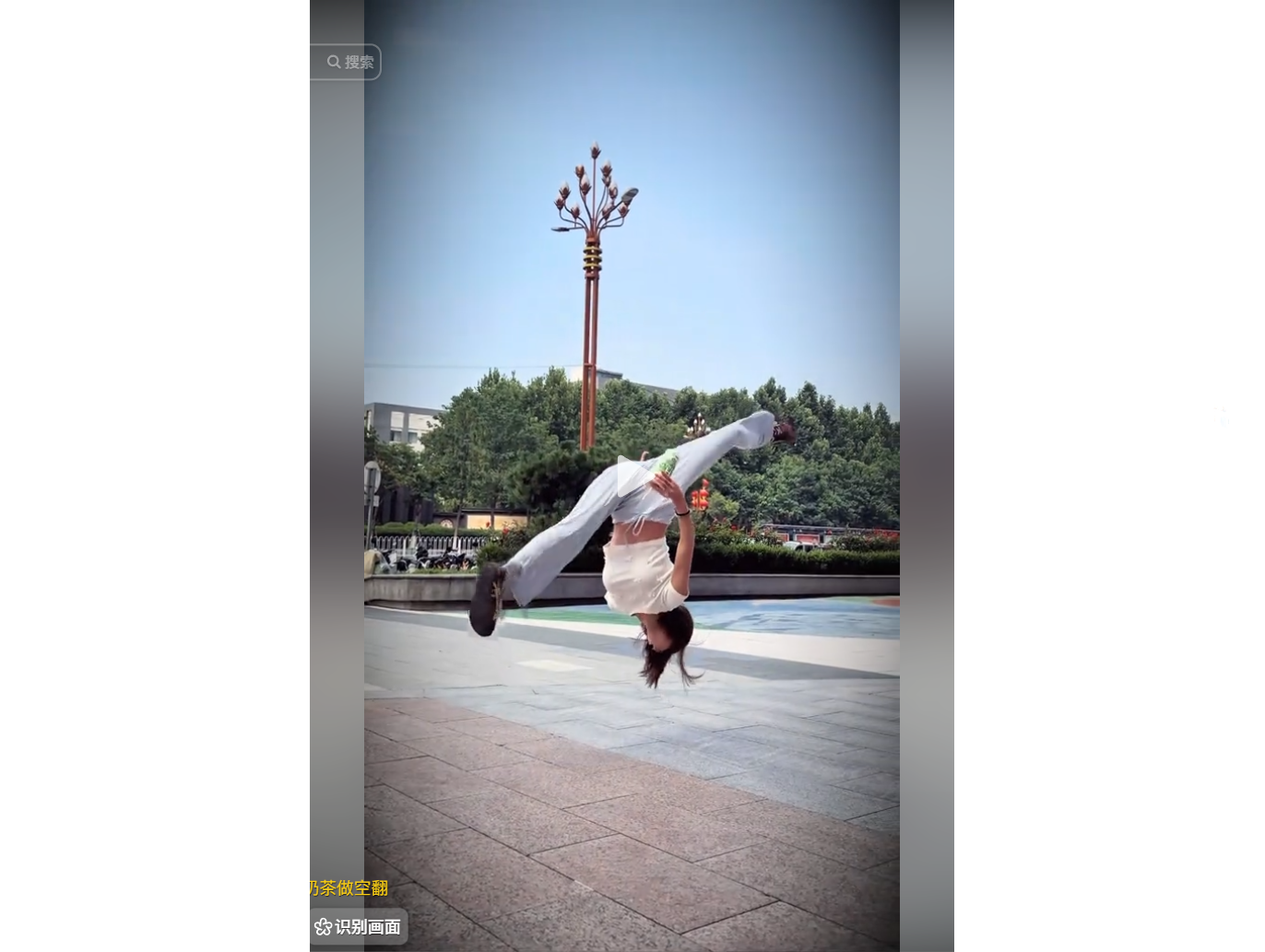 A person performs a backflip in an outdoor plaza, 