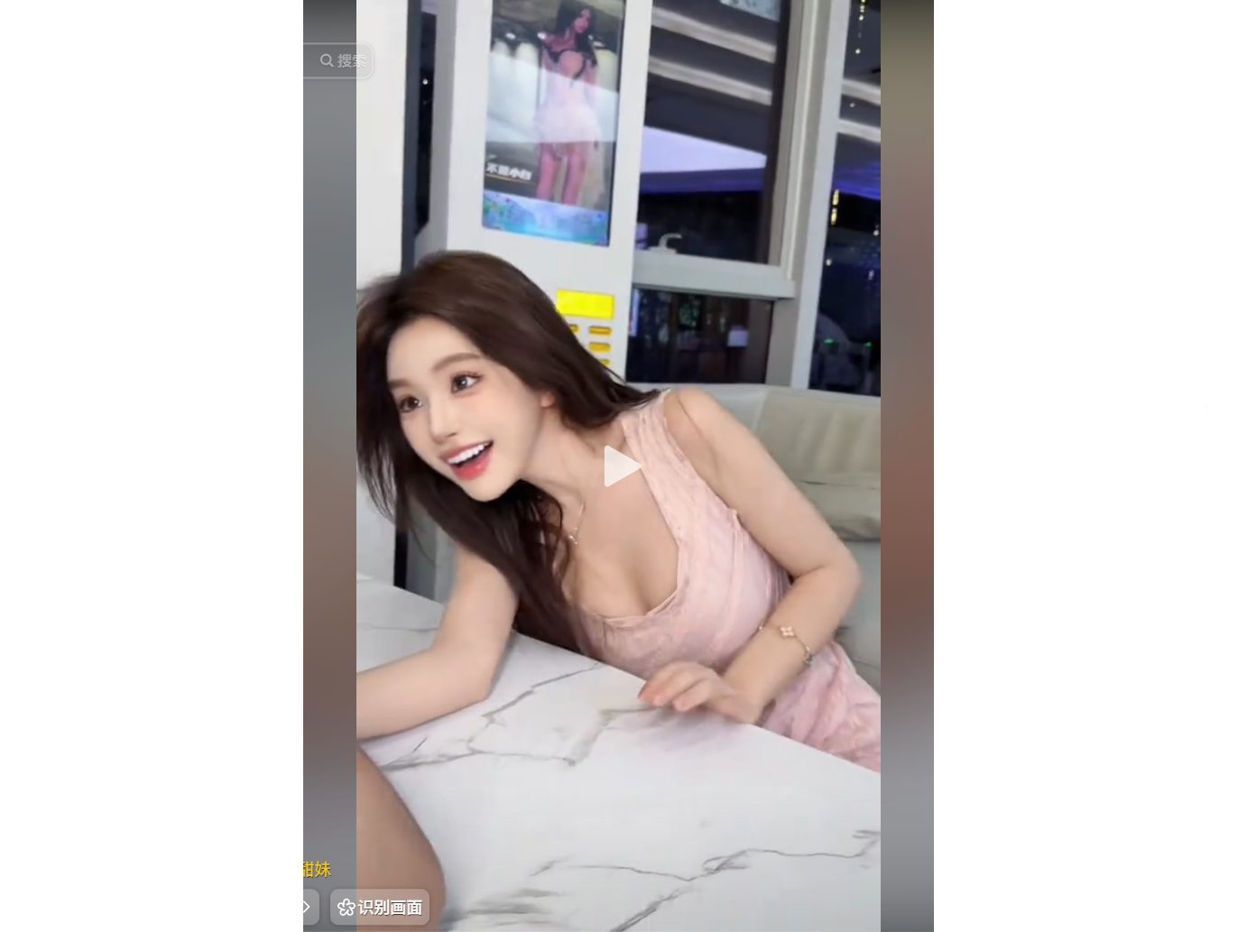 A woman in a pink dress smiles while leaning on a 